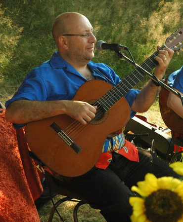 Zanger met akoestische gitaar tijdens een buitenoptreden
