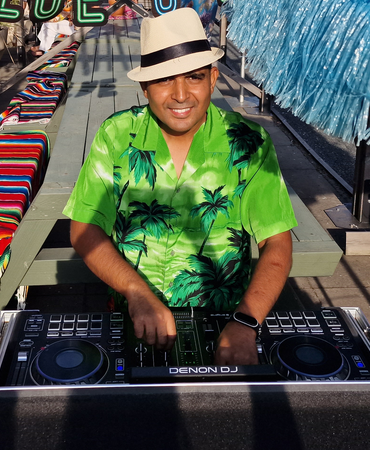 DJ met mengtafel op een tropisch aangekleed buitenfeest